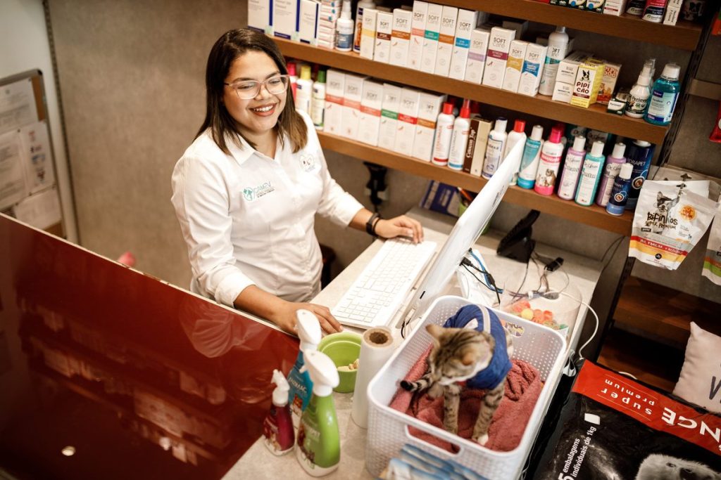 mulher jovem sorri ao olhar para computador 